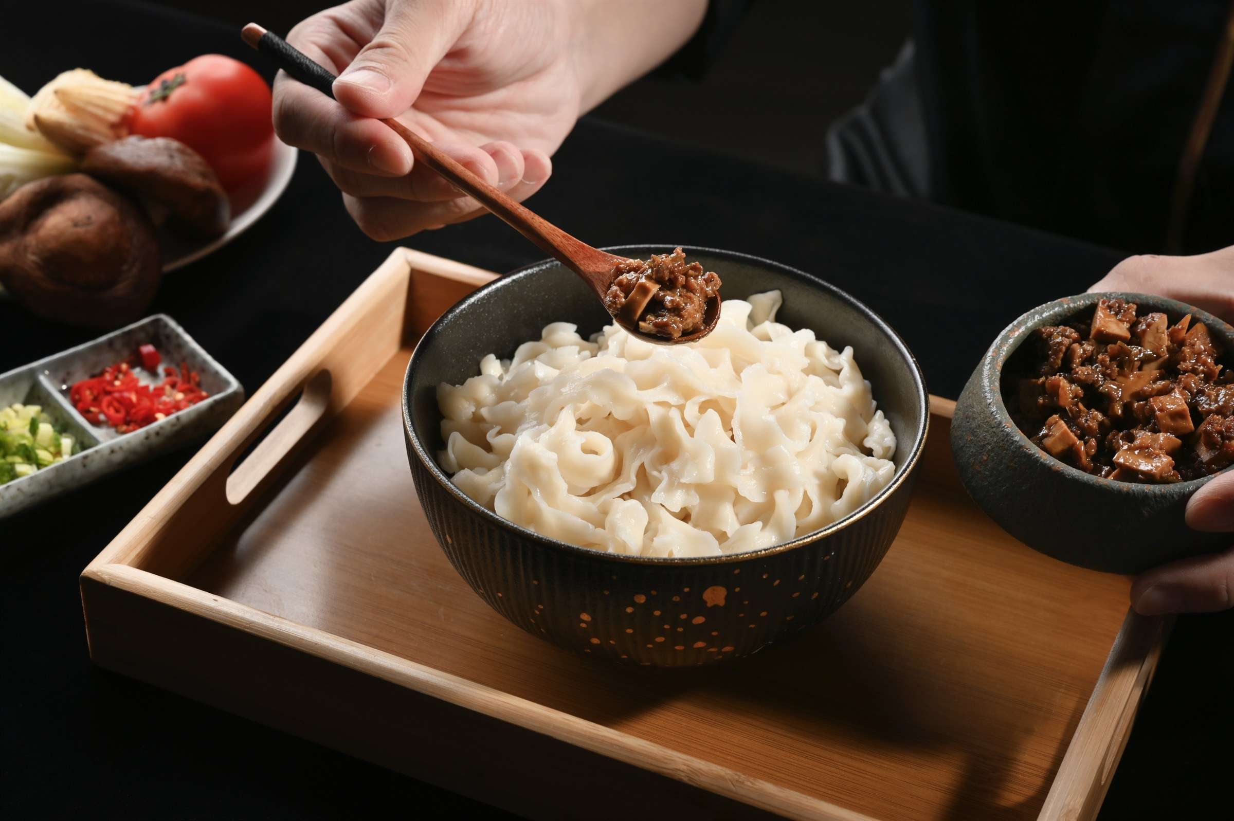 廚師將肉燥醬淋上寬麵，餐飲品牌料理過程攝影｜艾妃拉影像